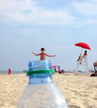 Water bottle low angle & a boy enjoying the beach looking like he is coming out of it. Tiny humans Water bottle low angle & a boy enjoying the beach looking like he is coming out of it. Tiny humans - PhotoDune Item for Sale