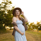 Smiling pregnant woman in summer dress and hat outdoors Smiling pregnant woman in summer dress and hat outdoors - PhotoDune Item for Sale