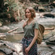 Attractive young female traveler with backpack standing by the mountain river and enjoying views Attractive young female traveler with backpack standing by the mountain river and enjoying views - PhotoDune Item for Sale