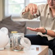 Asian man office worker counting coins in glass jar aside piggy bank sitting on sofa in living room Asian man office worker counting coins in glass jar aside piggy bank sitting on sofa in living room - PhotoDune Item for Sale