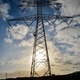 Low angle shot of a high transmission tower with a glow of sunlight in ...