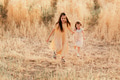 Two sisters little girls wear casual dresses having fun in wheat field. Kids in motion. Yellow color Two sisters little girls wear casual dresses having fun in wheat field. Kids in motion. Yellow color - PhotoDune Item for Sale
