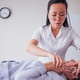 Female chiropractor in white uniform adjusts neck of patient lying on treatment table Female chiropractor in white uniform adjusts neck of patient lying on treatment table - PhotoDune Item for Sale