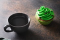 St. Patrick's Day coffee and green chocolate cupcake on brown background. St. Patrick's Day coffee and green chocolate cupcake on brown background. - PhotoDune Item for Sale