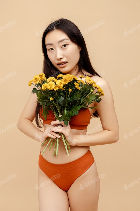 Beautiful young Asian woman wearing stylish sexy lingerie holding bunch of chrysanthemums Stock Photo by msvyatkovska Beautiful young Asian woman wearing stylish sexy lingerie holding bunch of chrysanthemums Stock Photo by msvyatkovska