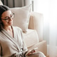 White woman using mobile phone while sitting with gift box on floor White woman using mobile phone while sitting with gift box on floor - PhotoDune Item for Sale