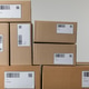 Stacked cardboard boxes with barcodes and qr codes isolated on grey ...