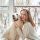 Woman hugging golden retriever dog by balcony window Woman hugging golden retriever dog by balcony window - PhotoDune Item for Sale