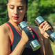 Athletic Woman Training With Small Hand Weights In A Green Park Setting Athletic Woman Training With Small Hand Weights In A Green Park Setting - PhotoDune Item for Sale