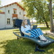 A blonde woman with a laptop works in the garden on a sun lounger, a green home office concept A blonde woman with a laptop works in the garden on a sun lounger, a green home office concept - PhotoDune Item for Sale