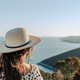 Back view of Female tourist with hat gazing at amazing coastline and sea Back view of Female tourist with hat gazing at amazing coastline and sea - PhotoDune Item for Sale