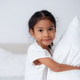 Happy girl hugging pillows on bed in bedroom Happy girl hugging pillows on bed in bedroom - PhotoDune Item for Sale