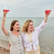Two young women toasting with pink wine at seaside picnic in soft natural light Two young women toasting with pink wine at seaside picnic in soft natural light - PhotoDune Item for Sale