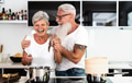 Happy senior couple having fun cooking together at home - Elderly people preparing health lunch Happy senior couple having fun cooking together at home - Elderly people preparing health lunch - PhotoDune Item for Sale