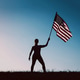 Silhouette of woman holding American flag. Silhouette of woman holding American flag. - PhotoDune Item for Sale