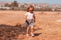 Little girl walking alone in field with dry grass. Scenic countryside life, unity with nature Little girl walking alone in field with dry grass. Scenic countryside life, unity with nature - PhotoDune Item for Sale