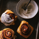 Baked cinnamon bun rolls with white vanilla bean cream frosting. Moody food photo.Closeup flat lay Baked cinnamon bun rolls with white vanilla bean cream frosting. Moody food photo.Closeup flat lay - PhotoDune Item for Sale