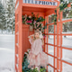 A little girl stands near a pink telephone booth filled with flowers in a snowy forest. Spring A little girl stands near a pink telephone booth filled with flowers in a snowy forest. Spring - PhotoDune Item for Sale