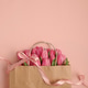 Gift Bag with Pink Tulips on Pink Background. Valentines or Mothers Day Celebration Gift Bag with Pink Tulips on Pink Background. Valentines or Mothers Day Celebration - PhotoDune Item for Sale