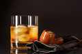 Scotch drink glass and smoking pipe on black background Scotch drink glass and smoking pipe on black background - PhotoDune Item for Sale