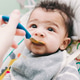 A baby eating purée food A baby eating purée food - PhotoDune Item for Sale
