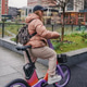 Riding rented electric bicycle during rainy commute. Ebike rental sharing supports urban transport Riding rented electric bicycle during rainy commute. Ebike rental sharing supports urban transport - PhotoDune Item for Sale