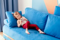 Caucasian little toddler girl wear casual clothes lying on blue coach in domestic room Caucasian little toddler girl wear casual clothes lying on blue coach in domestic room - PhotoDune Item for Sale