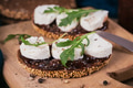 Bruschetta with fig jam, goat cheese and rucola on wooden plate Bruschetta with fig jam, goat cheese and rucola on wooden plate - PhotoDune Item for Sale