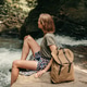 Young female traveler with backpack resting while sitting by the mountain river Young female traveler with backpack resting while sitting by the mountain river - PhotoDune Item for Sale