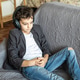 Young boy wearing headphones relaxing on a gray sofa at home for music listening Young boy wearing headphones relaxing on a gray sofa at home for music listening - PhotoDune Item for Sale