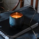 Lit candle in ceramic cup on notebook with branches and fabric Lit candle in ceramic cup on notebook with branches and fabric - PhotoDune Item for Sale