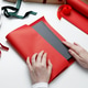 Woman wrapping book using red gift paper for special occasion Woman wrapping book using red gift paper for special occasion - PhotoDune Item for Sale