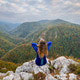 Young woman with long hair sitting on a cliff admiring the mountains in autumn Young woman with long hair sitting on a cliff admiring the mountains in autumn - PhotoDune Item for Sale