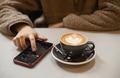 Girl in fluffy sweater writes on smartphone kissing emoji message next to cup of coffee with heart Girl in fluffy sweater writes on smartphone kissing emoji message next to cup of coffee with heart - PhotoDune Item for Sale