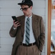 young man in vintage clothes jacket looks at the phone in surprise young man in vintage clothes jacket looks at the phone in surprise - PhotoDune Item for Sale