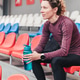 Lady in sportswear with bottle of water sits at stadium Lady in sportswear with bottle of water sits at stadium - PhotoDune Item for Sale