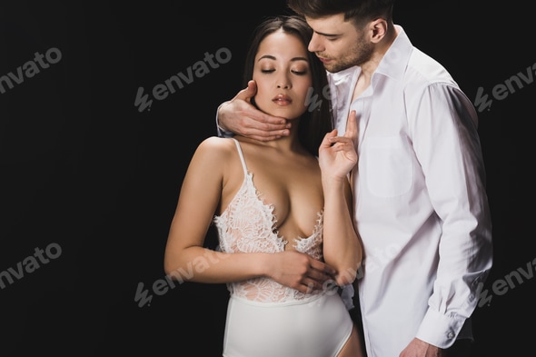 handsome young man embracing sexy asian girlfriend in white lingerie isolated on black Stock Photo by LightFieldStudios handsome young man embracing sexy asian girlfriend in white lingerie isolated on black Stock Photo by LightFieldStudios