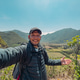 Cheerful ethnic guy taking selfie against mountainous terrain under blue sky Cheerful ethnic guy taking selfie against mountainous terrain under blue sky - PhotoDune Item for Sale