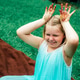 Cute little girls shows her dirty colored with paints palms sitting on blanket on grass in backyard. Cute little girls shows her dirty colored with paints palms sitting on blanket on grass in backyard. - PhotoDune Item for Sale