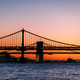 Suspension bridge over rippling river against sundown Suspension bridge over rippling river against sundown - PhotoDune Item for Sale