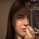 Young woman with long hair holds a clear water bottle close to her face Young woman with long hair holds a clear water bottle close to her face - PhotoDune Item for Sale