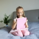 Young girl using tablet while sitting on a bed at home Young girl using tablet while sitting on a bed at home - PhotoDune Item for Sale