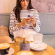 Woman using her phone for social media while drinking coffee with friends. Woman using her phone for social media while drinking coffee with friends. - PhotoDune Item for Sale