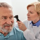 Hearing test for mature people, otoscopy. Otolaryngologist doctor checking senior man's ear Hearing test for mature people, otoscopy. Otolaryngologist doctor checking senior man's ear - PhotoDune Item for Sale