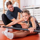 Trainer assisting a young girl performing a corrective stretching exercise Trainer assisting a young girl performing a corrective stretching exercise - PhotoDune Item for Sale