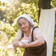 beautiful mature european woman in her 50s doing laundry by hand outdoors. beautiful mature european woman in her 50s doing laundry by hand outdoors. - PhotoDune Item for Sale