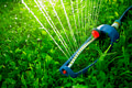 Lawn sprinkler spaying water over green grass Lawn sprinkler spaying water over green grass - PhotoDune Item for Sale