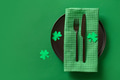 Festive table setting with St Patrick's Day green decoration on green background. Festive table setting with St Patrick's Day green decoration on green background. - PhotoDune Item for Sale