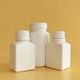White plastic pharmaceutical containers on yellow background White plastic pharmaceutical containers on yellow background - PhotoDune Item for Sale