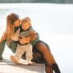 Mother holding baby 1-2 year old wearing knitted sweater sitting on wooden pier over lake Mother holding baby 1-2 year old wearing knitted sweater sitting on wooden pier over lake - PhotoDune Item for Sale